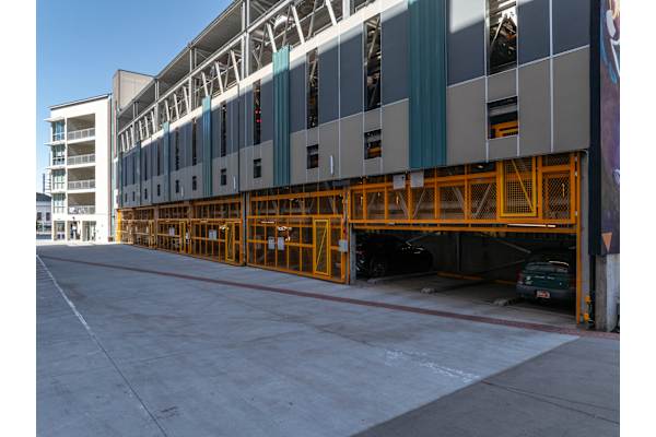 A large building with a grey and white exterior and a yellow support structure. at Paperbox Lofts Apartments, Apartments, Salt Lake City  , UT